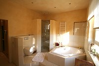 Bad mit gemauerter Duschkabine, WC und Sechseck-Badewanne, komplett auf einem Sockel