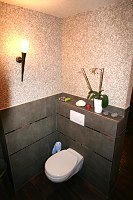 Modernes WC mit Baumwollputz oberhalb der Fliesen