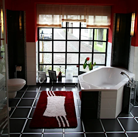 Bad mit Fliesen Schwarz und Weiß, roten Wänden und integrierter Fiberglasbeleuchtung mit Farbwechsel