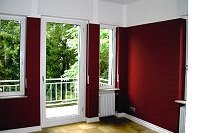 Wohnraum mit angelegten Tapeten in Rot/Weiß gestaltet